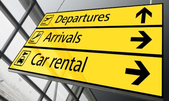 A sign at the airport showing the way to the car rental office, arrivals and departures hall