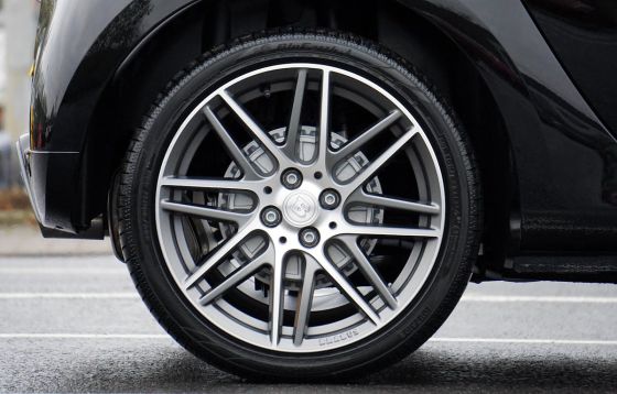 The wheel of a black car with a shiny tire