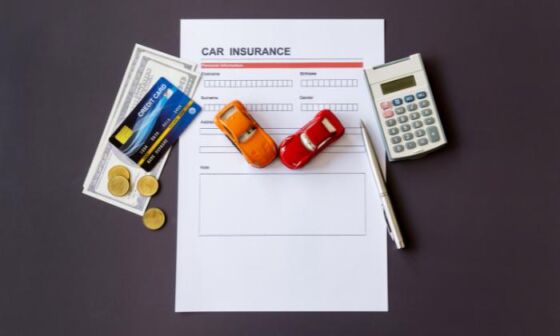 Car insurance, as well as a calculator, card and money on a printed contract