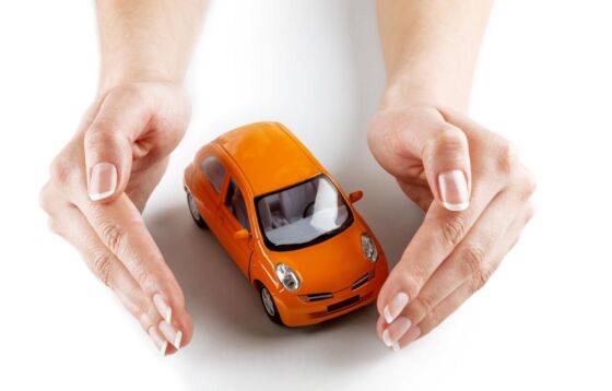 A toy car protected by hands